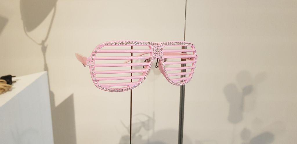 Diese rosarote Brille, die eigentlich gar keine Brille ist, grüsste schon von manchem hippen Nasenrücken. Anstelle eines verdunkelten Glases besteht sie aus farbigen «Stäben» und erfüllt somit ihren Hauptzweck, in einem Nachtklub nicht zu einem Hindernis zu werden.