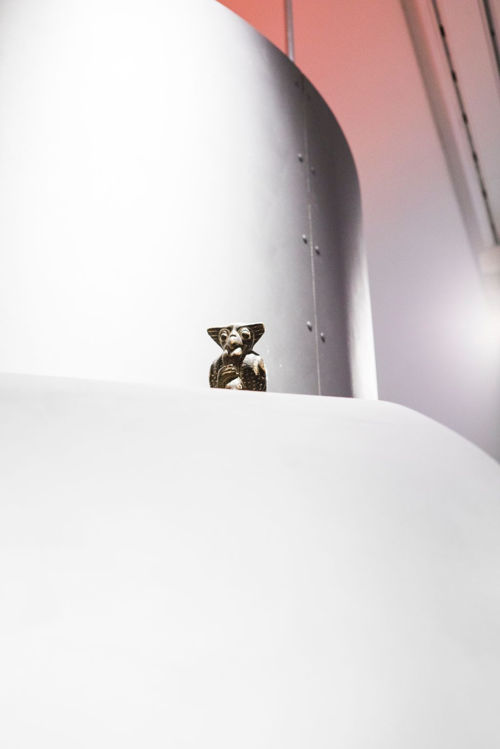 Das Bild zeigt eine Nahaufnahme eines Raketenteils in der Ausstellung «Sonne, Mond und Sterne». Auf einer Röhre sitzt eine kleine Eule.