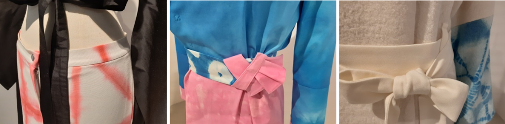Es ist eine Collage aus drei Bildern mit Details von Kleidern. Links flattert ein schwarzes Oberteil über eine weisse Hose, die ein rosa-Sibori-Muster aufweist. In der Mitte ist ein Gürtel in Rosa, Weiss und Blau zu sehen. Rechts ebenfalls ein Gürtel eines Kleides, der blau-weisse-Shibori-Musterung aufweist.