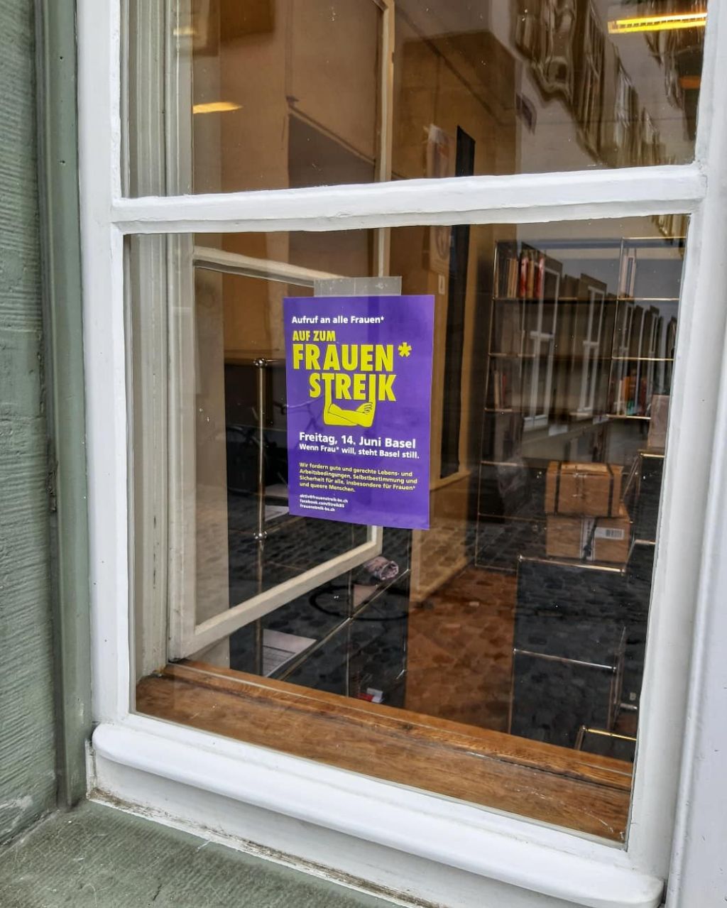 In einem Fenster des Museums, auf Augenhöhe der Passanten am Münsterplatz, hängt ein kleine Frauenstreikplakat.