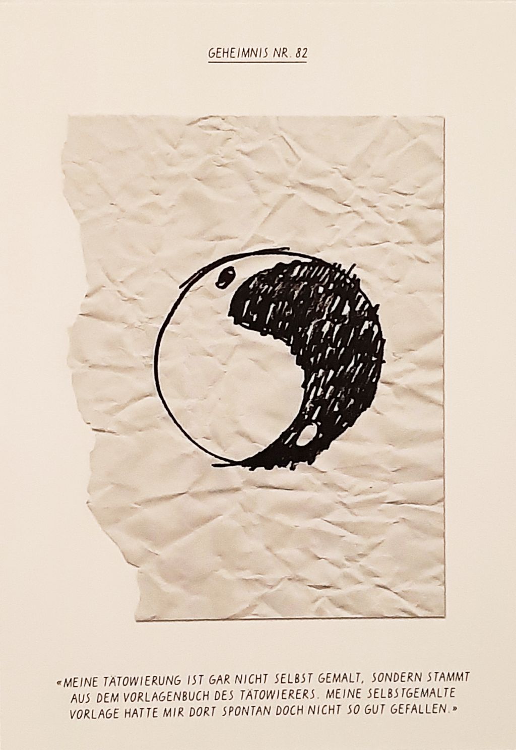 Auf einem zerknüllten Zettel sehen wir ein Yin und Yang-Symbol.
