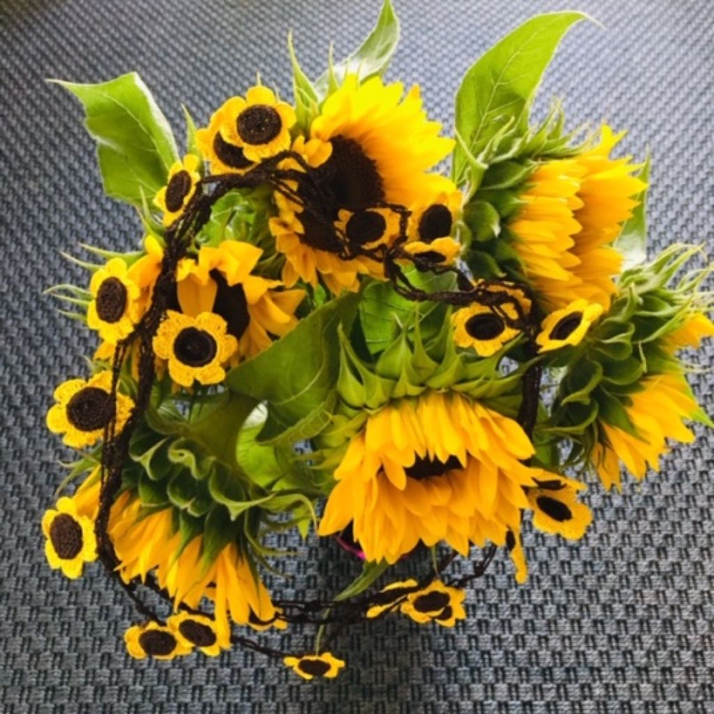 Die filigranen Ketten sehen nicht selten aus wie Blumen. In diesem Bild sehen sie aus wie Sonnenblumen in voller Pracht und wurden über einen Strauss ebendieser Sonnenblumen gelegt.