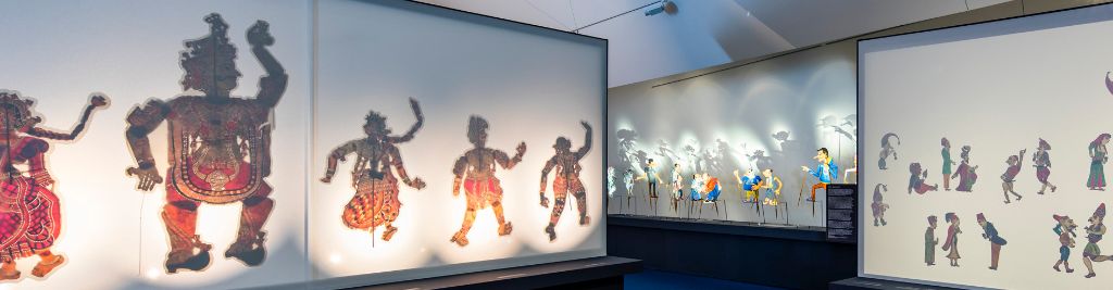 Blick in die Ausstellung «Bima, Kasper und Dämon», auf verschiedene Leinwände und Wände, auf denen Schattenfiguren und Schatten zu sehen sind