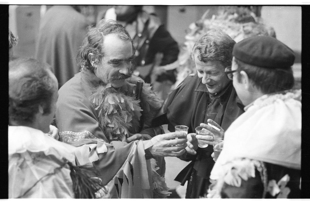 Jean Tinguely stosst mit einem Glas mit seinen Freunden an der Basler Fasnacht an