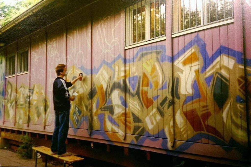 Magoo als Jugendlicher am Sprayen an die Aussenfassade eines Jugendtreffpunktes in Basel