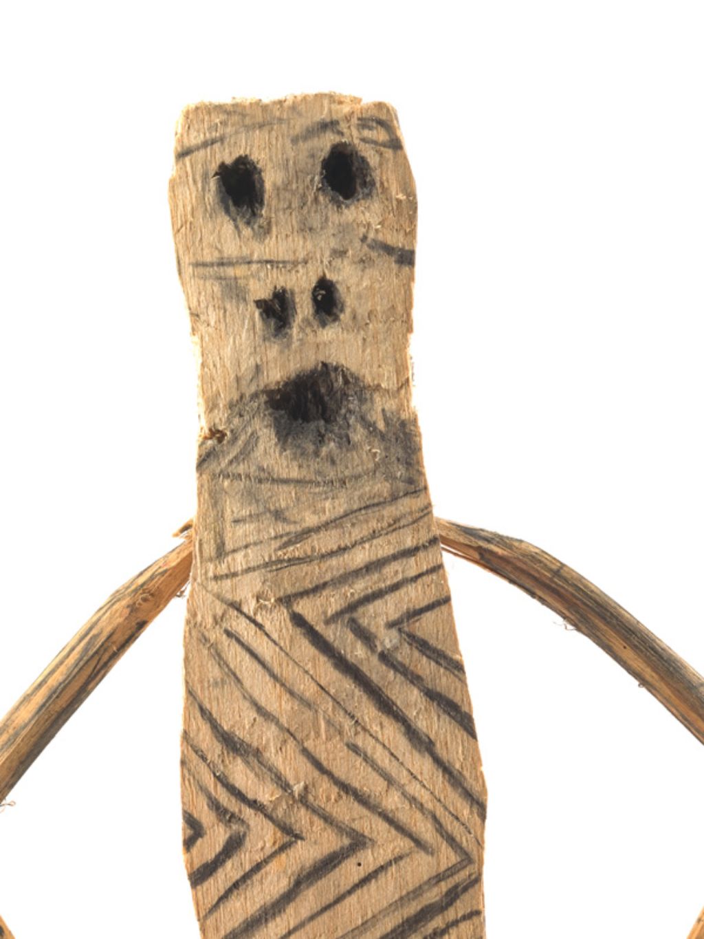 Holzmännchen mit dünnen Armen und einem mit Zickzacklinien verzierten Körper, dessen Augen, Nasenlöcher und Mund aus Löchern bestehen.