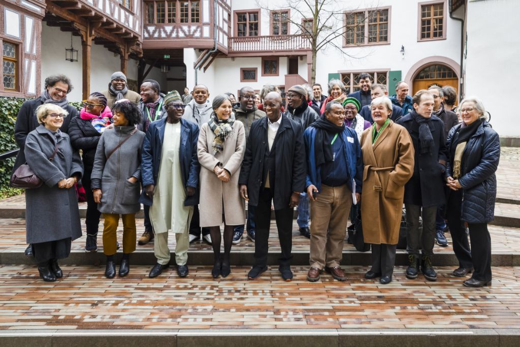 Eine Gruppe von Personen steht auf den Stufen des Innenhofs des Museums, im Hintergrund sieht man die mittelalterlichen Gebäude.