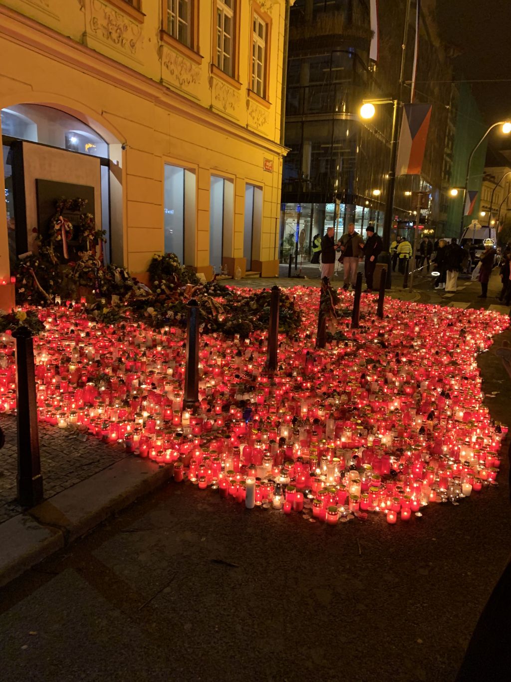 Bei Nacht strahlen tausende von Kerzen vor einem beleuchteten Gebäude.