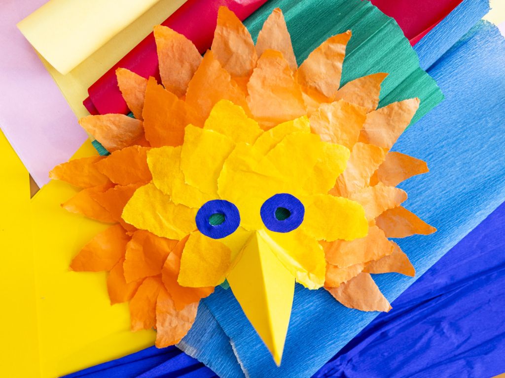 Maske in Form eines Vogels mit langem Schnabel, gebastelt aus farbigem Papier.
