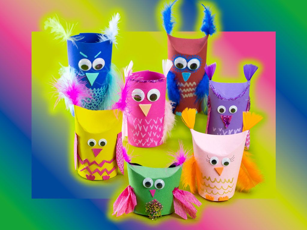 Acht unterschiedlich grosse gebastelte Eulen aus Pappe, Federn und farbigem Papier. Die Eulen haben grosse runde aufgeklebte Augen.